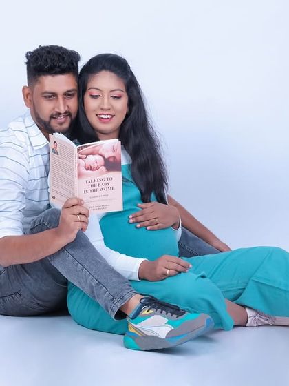 A sweet studio moment with an expecting couple reading a book about parenting together. It's a charming and candid way to capture their journey into parenthood.