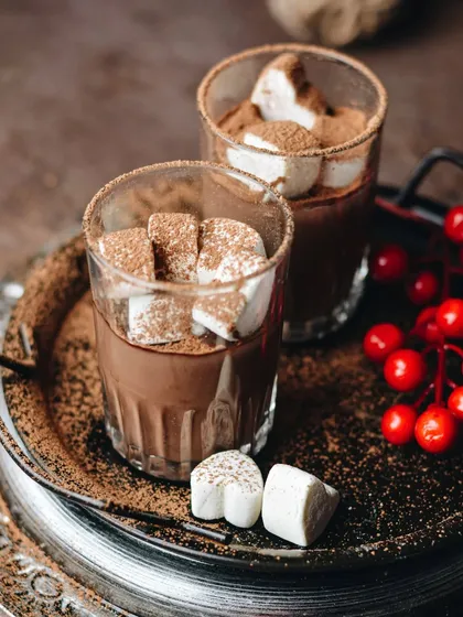 A decadent hot chocolate with marshmallows, shot with a moody, rustic feel. The rich brown tones and the dusting of cocoa powder make it the perfect treat for a chilly day.
