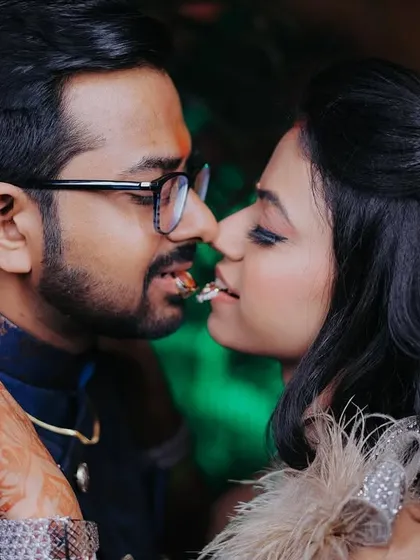 A playful and intimate shot where the couple holds one of the rings between their lips. It's a fun and quirky idea that shows their personalities.