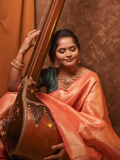 Styling singer Sharayu Date for a photoshoot with her veena. This peach silk saree creates a look that is both classic and soft, perfect for a musician's portrait.