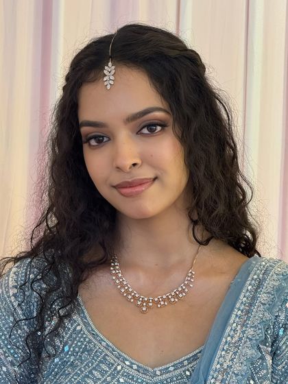 A close-up of Dr. Sushmita's reception look. The makeup is natural and glamorous, with a soft brown smoky eye and a nude lip that lets her natural beauty shine.