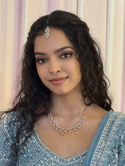 A close-up of Dr. Sushmita's reception look. The makeup is natural and glamorous, with a soft brown smoky eye and a nude lip that lets her natural beauty shine.