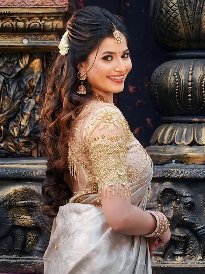 A side profile showcasing the elegant hairstyle and intricate gold embroidery on the blouse. We believe in creating a complete, cohesive look from every angle.