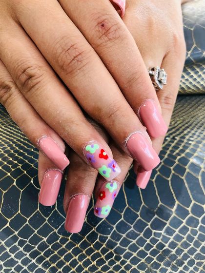 A sweet pink set with accent nails featuring colorful, hand-painted 3D flowers.