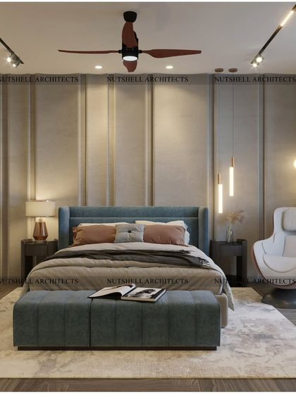 The bed in this room is set against a wall with subtle molding and integrated lighting, creating a calm and serene backdrop. A comfortable massage chair by the window offers a perfect spot for relaxation.