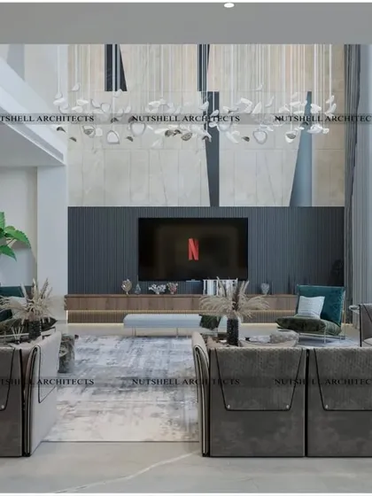 A double-height living room designed for ultimate comfort. The large, modular sofa provides ample seating, while the towering TV wall and dramatic chandelier draw the eye upwards, emphasizing the grand scale of the space.