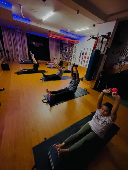 A wide shot of our Pilates session in action. You can see the energy of the group as they work on their core strength using light dumbbells for added resistance.