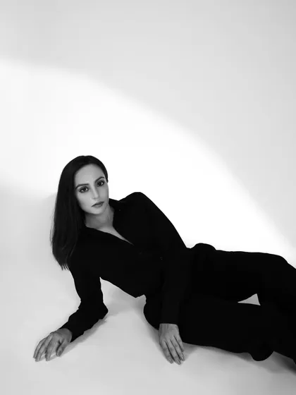 A minimalist black and white shot for a contemporary London brand. The clean, high-key background and the model's pose create a sophisticated and timeless image.