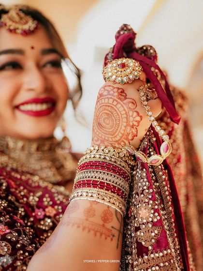 A detail shot of bride Reshma's hands, focusing on her beautiful henna and traditional kalire. These close-ups highlight the artistry of Indian bridal traditions.