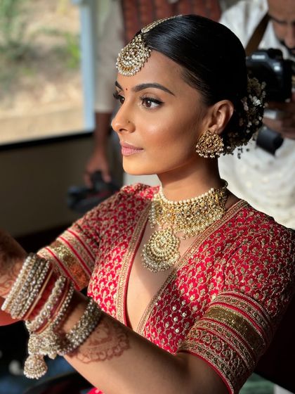 A beautiful side profile showing the flawless application of makeup and the intricate details of the hairstyle.