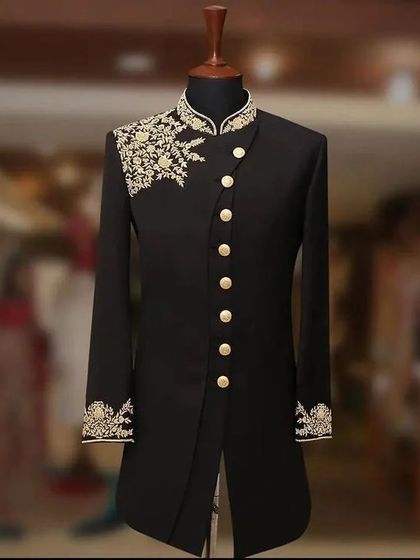 This black Indo-western jacket showcases beautiful gold embroidery on the shoulder and cuffs. The asymmetrical cut gives it a contemporary edge, perfect for a formal evening event.