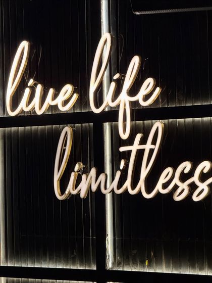 The "Live Life Limitless" neon sign at Limitless Luxe, capturing the vibrant and aspirational vibe of the place.