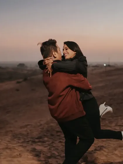 A joyful hug in a vast desert landscape at dusk. This photo captures a sense of adventure and romance, showcasing our ability to shoot in diverse and epic locations.