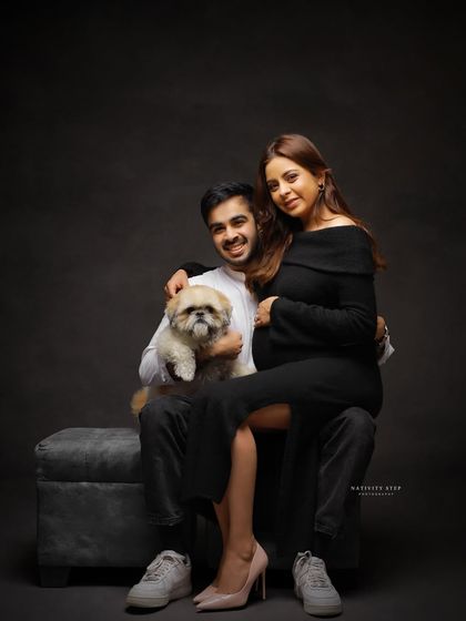 A stylish and modern family portrait with their adorable dog. This studio shot shows that pets are always welcome to join in the celebration.