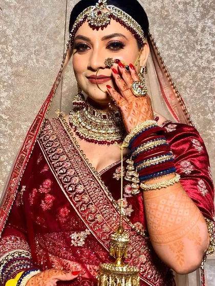 Here is another angle of this beautiful bride, showcasing her complete look. From the flawless makeup and intricate jewelry to the perfectly manicured red nails, every detail came together for her special day.