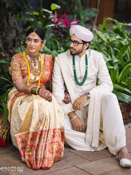 A regal portrait of the couple in traditional attire, with the bride's stained henna adding to her elegance.