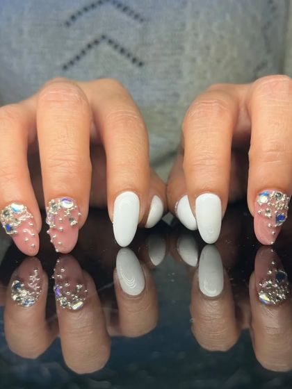A full view of the striking white and 3D rhinestone cluster manicure.