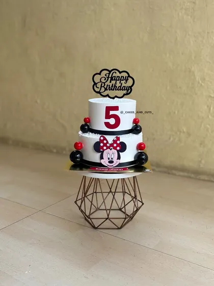 A fun Minnie Mouse cake for a fifth birthday. The two-tier design in classic red, black, and white is a timeless choice for Disney fans.