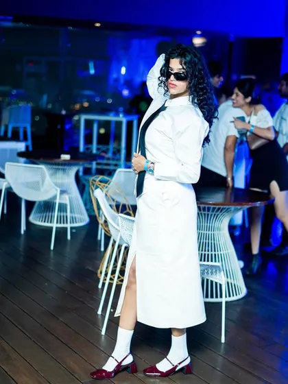 A stylish guest dressed in white, embodying the theme of the party. Our events attract a fashion-conscious crowd that embraces our creative concepts.