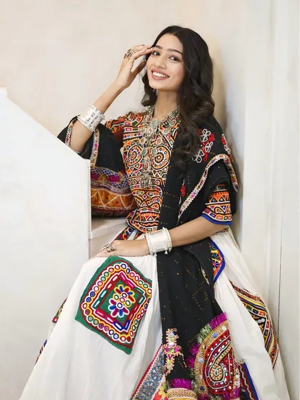The complete traditional Gujarati look for Navratri. We paired her colorful outfit with classic silver jewelry and a makeup look that enhances her natural beauty.