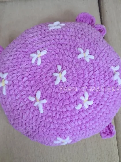 This plush, round whale pillow is made with super-soft, thick yarn and is embroidered with little white flowers for a whimsical touch.