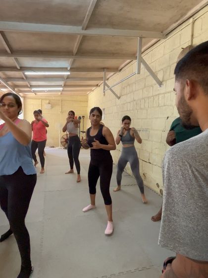 A coach demonstrating the proper boxing stance to the class.