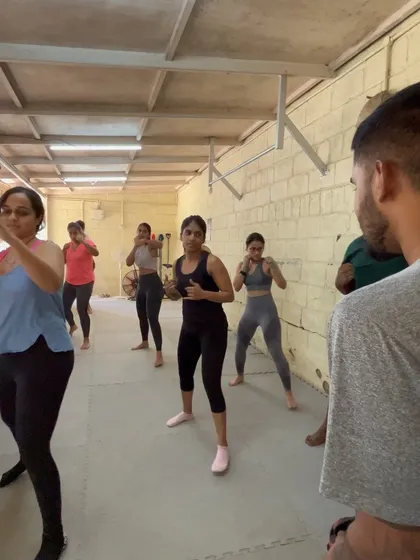 A coach demonstrating the proper boxing stance to the class.