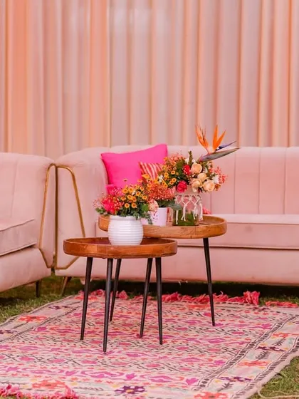 Another lounge setup with blush pink sofas and vibrant orange and pink cushions, creating a chic and comfortable space for guests.