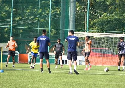My coaches observing and guiding athletes through an agility drill using cones and markers. This demonstrates our attention to detail in refining movement patterns for better on-field performance.