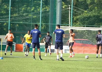 My coaches observing and guiding athletes through an agility drill using cones and markers. This demonstrates our attention to detail in refining movement patterns for better on-field performance.