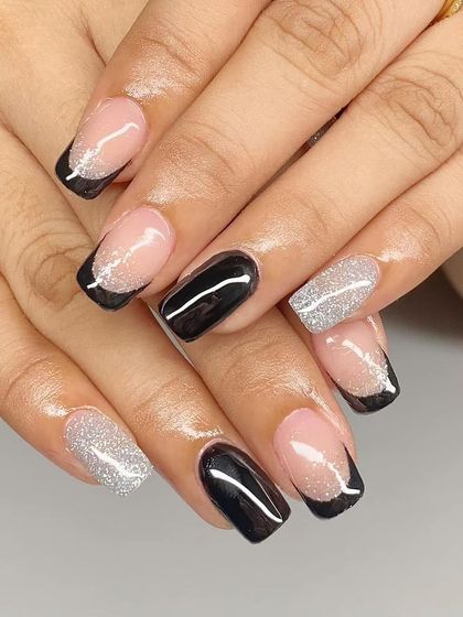 A stylish black and silver glitter French manicure on square-shaped nails.