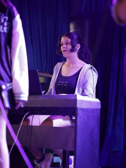 A keyboardist holds down the harmony for her band. Playing in an ensemble teaches you how your part fits into the bigger picture, a core focus of our band coaching program.