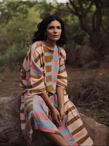 This outdoor shoot features a color-blocked dress from a conscious fashion brand. The combination of earthy tones and soft pastels in the dress works beautifully with the natural setting, creating a serene and stylish image.