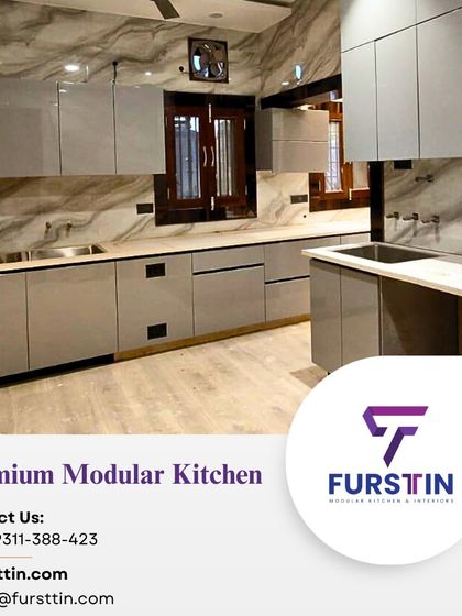 An L-shaped premium modular kitchen with a glossy grey finish and marble-patterned walls, creating a sophisticated and modern look.