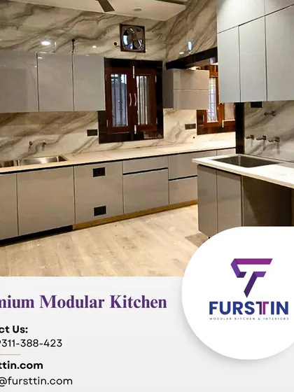 An L-shaped premium modular kitchen with a glossy grey finish and marble-patterned walls, creating a sophisticated and modern look.