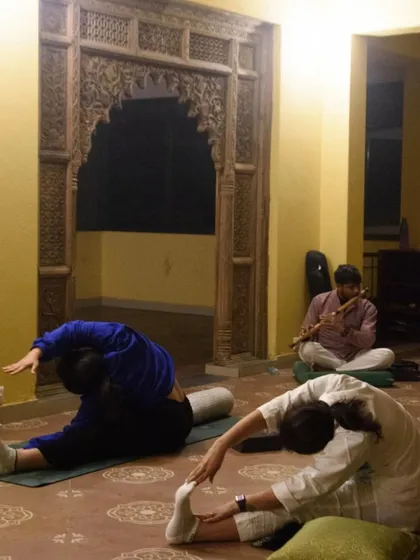 Participants flowing through asanas in a tranquil shala during our Dehradun retreat. These moments of shared practice, surrounded by nature and accompanied by live flute music, create a space for connection and growth.