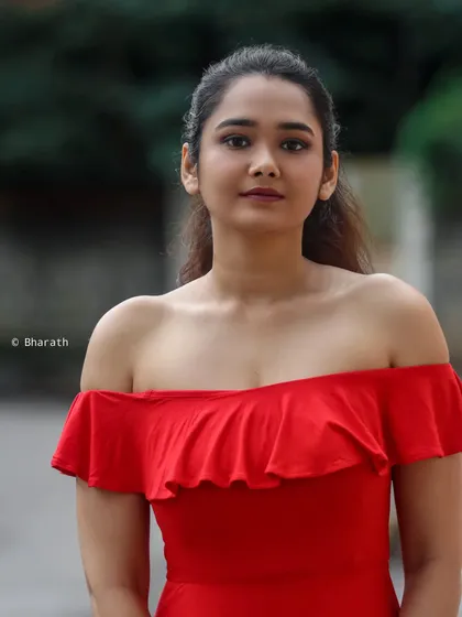 A close-up shot of the model in the red dress, focusing on her gentle expression and the delicate ruffle detail of the neckline.