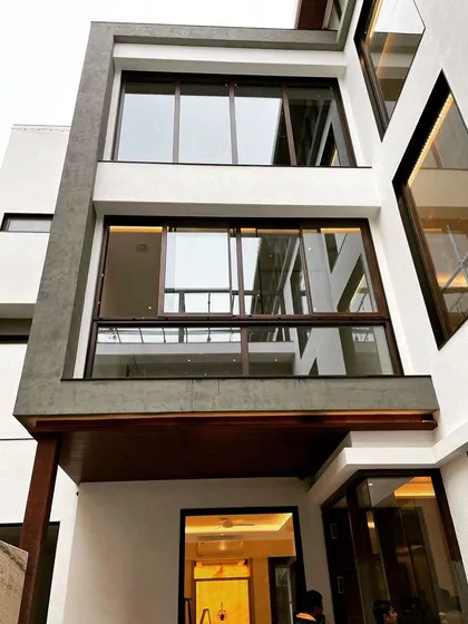 This image captures the intricate window and frame details of a residence nearing completion, showcasing the clean lines and modern aesthetic.