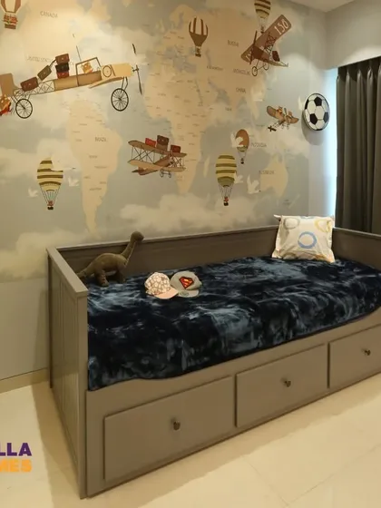 For the little adventurer, we designed this travel-themed room. The wall features a world map mural with vintage airplanes and hot air balloons, paired with a practical daybed with built-in storage drawers.