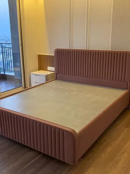 We would keep our alarm clock off on this bed. This custom upholstered bed in a soft pink is the centerpiece of a serene bedroom, proving that comfort and high style can definitely coexist.
