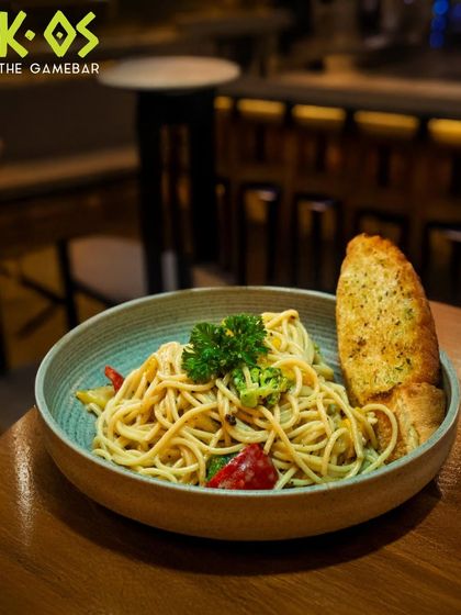 Twirl it, taste it, and enjoy. A classic bowl of spaghetti aglio e olio, served with a side of crispy garlic bread.