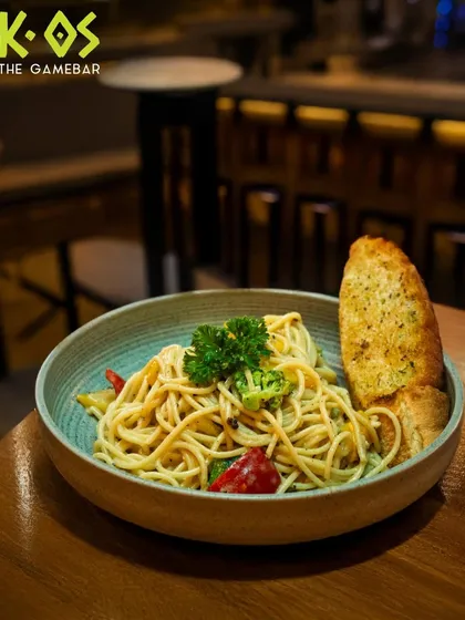 Twirl it, taste it, and enjoy. A classic bowl of spaghetti aglio e olio, served with a side of crispy garlic bread.