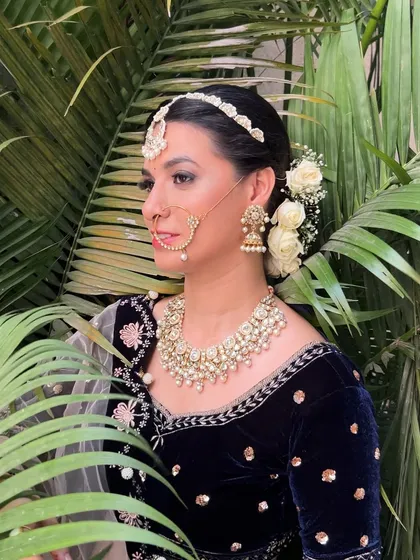 A profile view showing the elegant matha patti and the white rose bun.