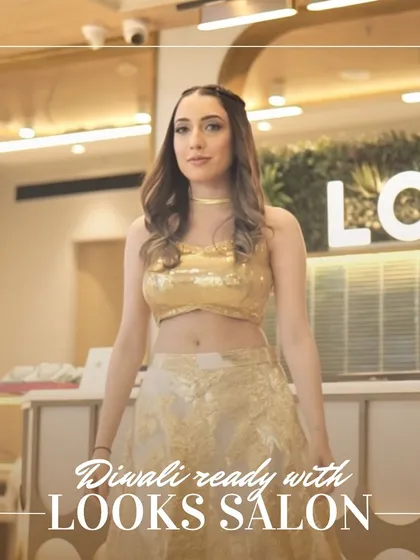 A model ready for Diwali celebrations, dressed in a sparkling gold outfit. Her makeup is glamorous and her hair is styled in soft waves.