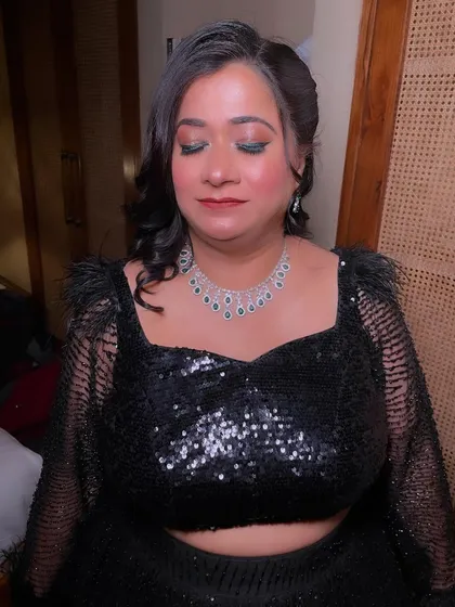 A close-up of the green-toned smokey eye, which adds a beautiful pop of color to the all-black outfit.