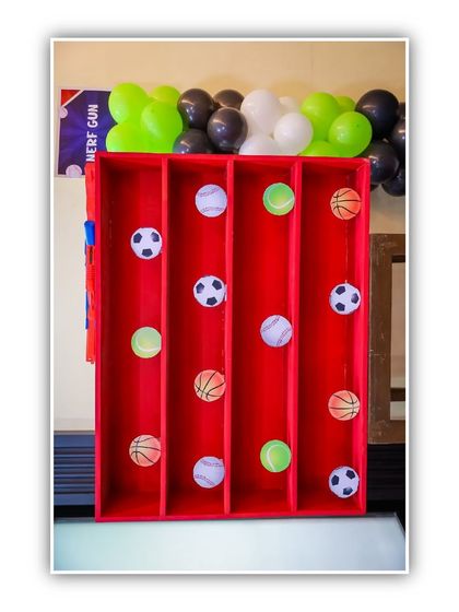 A sports-themed ball toss game. This simple yet challenging game is a great addition to a sports-themed party, testing kids' coordination and aim.