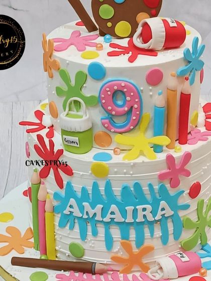 A close-up of the details on the artist-themed cake, including fondant paint tubes, crayons, and colorful splashes that bring the creative theme to life.