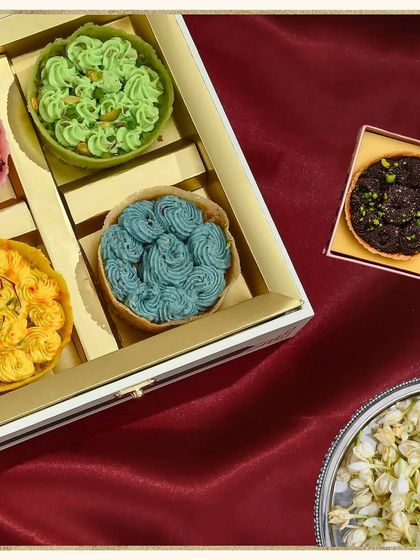 A beautifully packed box of four assorted mini ghewars, including rose, pistachio, blueberry, and saffron flavours. It's a perfect tasting box to share.