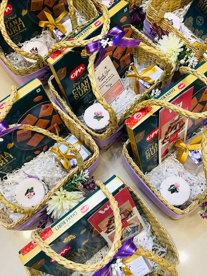 An overhead view of my wedding return gift hampers being assembled. Each basket is carefully packed with sweets and other favors, showing the consistent quality and attention to detail I provide for bulk orders.