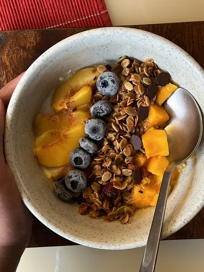 Start your day with a bowl of pure goodness. Our handmade granola, packed with fiber, good fats, and protein, is shown here served with yogurt and fresh fruit for a wholesome and delicious breakfast.